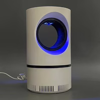 Lampe ZapiTrap posée près du lit, câble USB visible